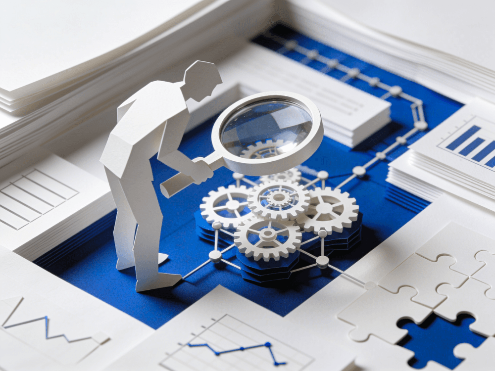 Papercraft figure examining interlocking gears through a magnifying glass, surrounded by charts