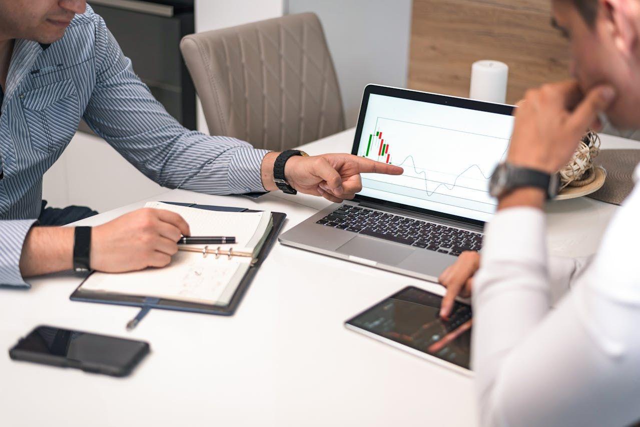 Professionals reviewing investment charts on a laptop during a meeting, representing institutional-quality analysis and U.S. real estate evaluation